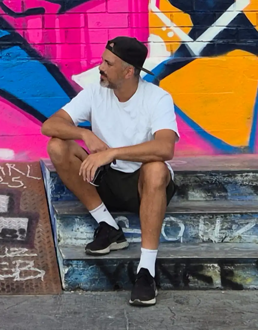 Artist Mr.P Grfx sitzt auf der Treppe in Lissabon, vor seinem Wand Graffiti